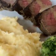 white plate of mashed potatoes, steak, and broccoli