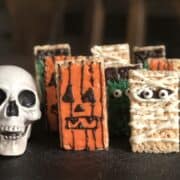 plastic skull halloween decoration and rice krispie treats decorated like a mummy frankenstein and jack-o-lantern