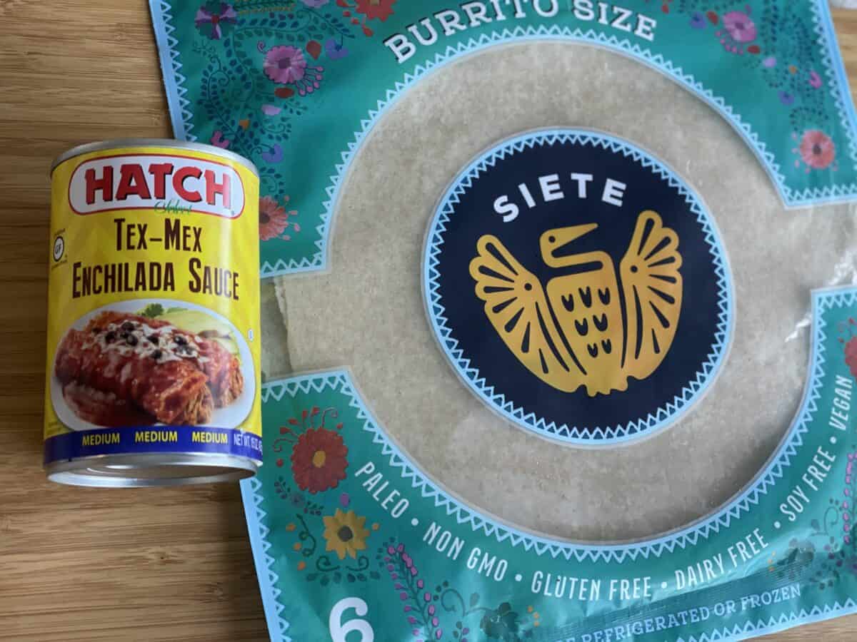 a can of hatch tex mex enchilada sauce and site brand burrito size tortillas on a wood cutting board