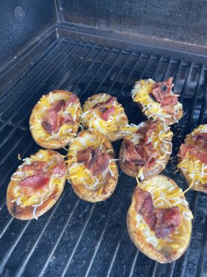 potato skins on the grill and filled with shredded cheese and cooked bacon