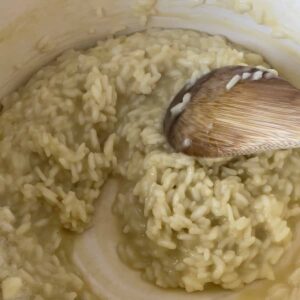 risotto cooking in the pot with a wooden spoon