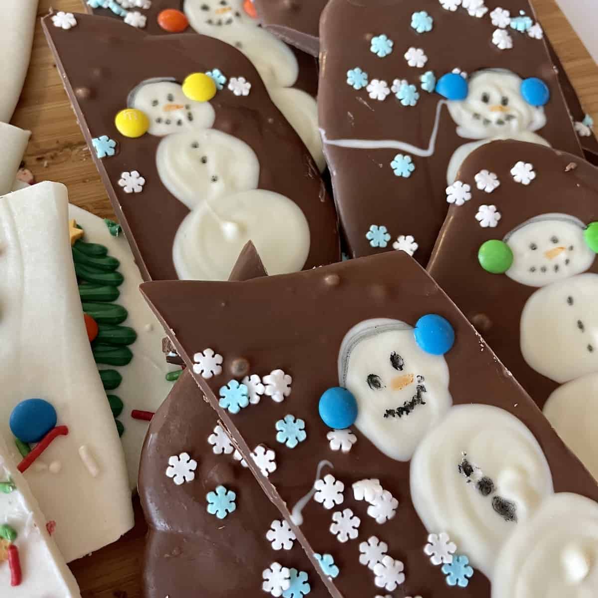 milk chocolate bark with white chocolate snowmen and snowflake sprinkles