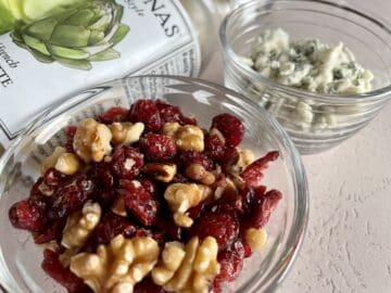 glass bowls of salad toppings including cranberry walnut blue cheese crumbles and briannas salad dressing