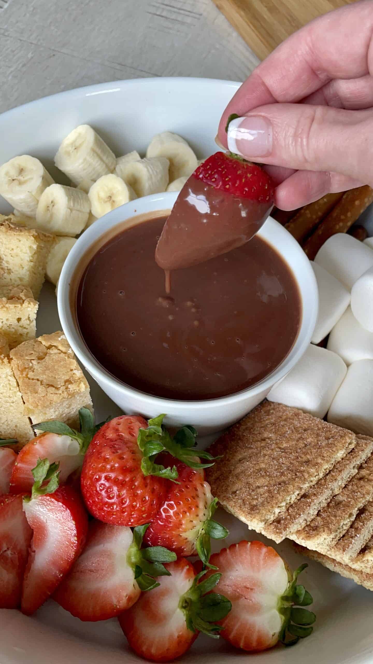 strawberry dipping into chocolate dipping sauce