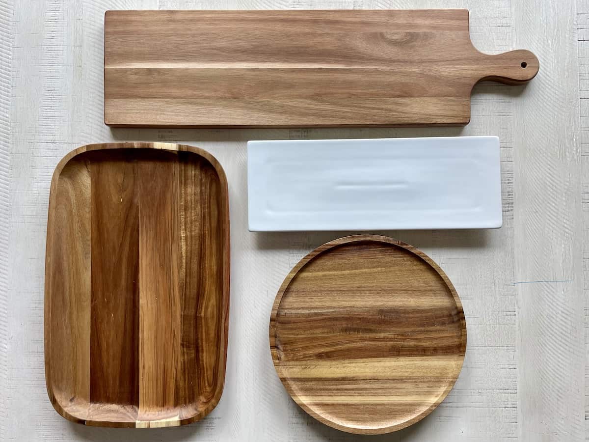 3 wood boards of different shapes and a white porcelain serving platter