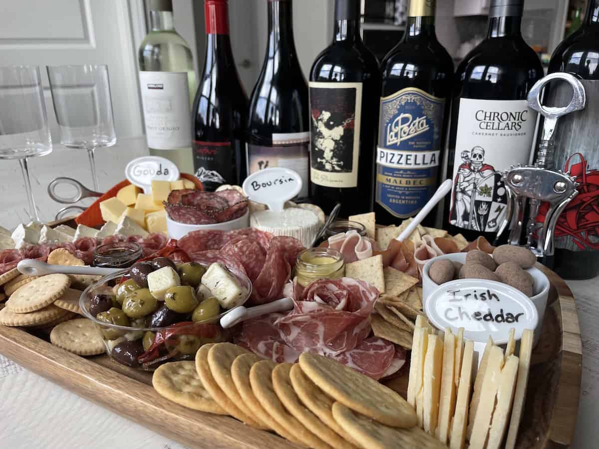 best wines for a charcuterie board including a few white wines and 4 reds with a charcuterie board comprised of crackers charcuterie meats cheeses and spreads
