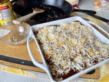 assembled casserole in a white baking dish with dirty dishes from cooking in the background 