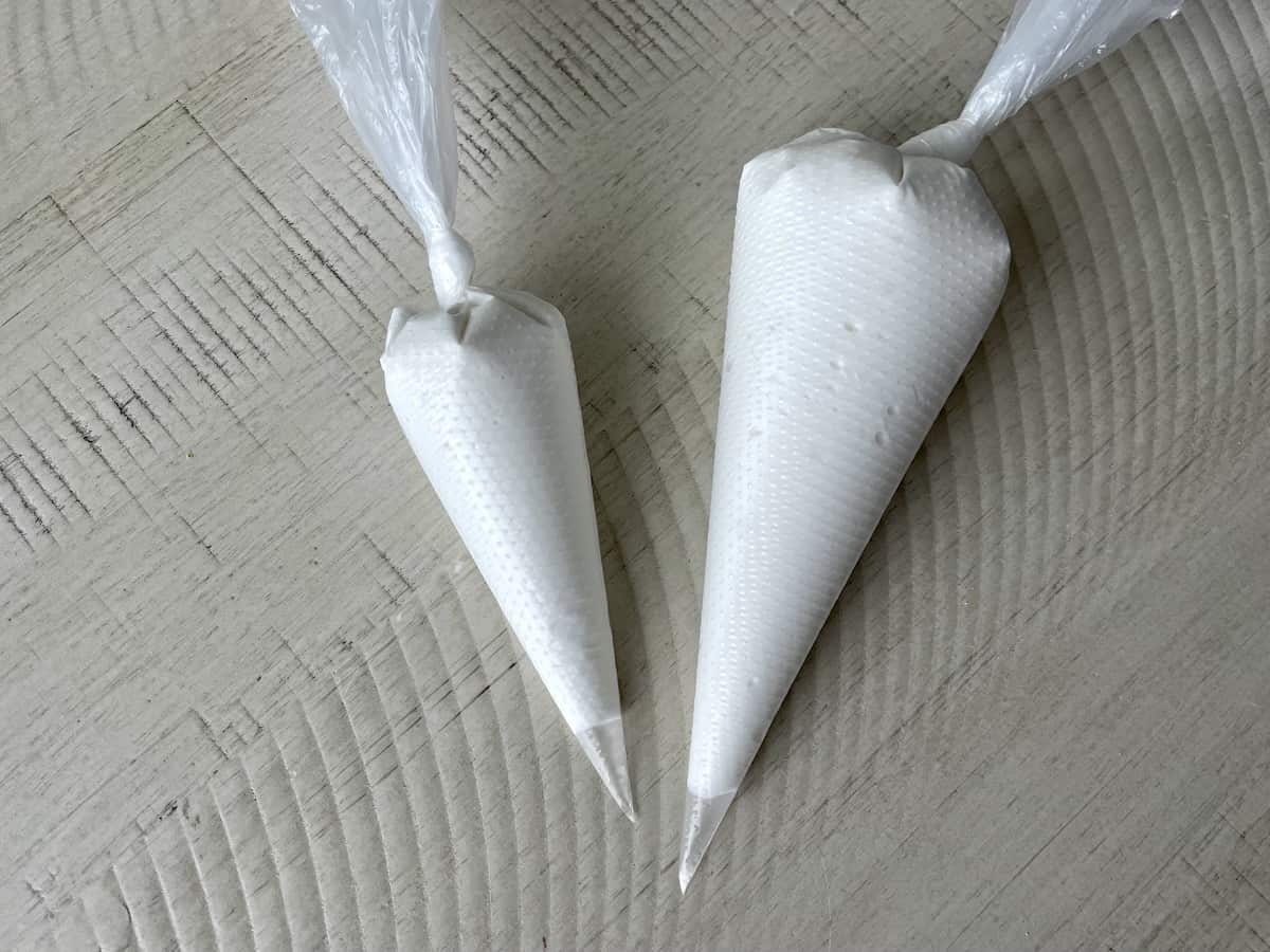 piping bags of royal icing on white kitchen table
