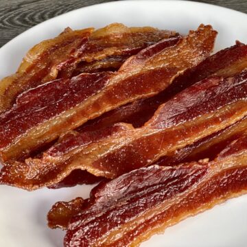 cooked bacon jerky laid on a white plate