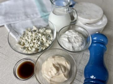 blue cheese dressing ingredients on a white table with a white blue and green kitchen towel