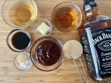 Jack Daniels sauce recipe ingredients in small bowls on a wood cutting board
