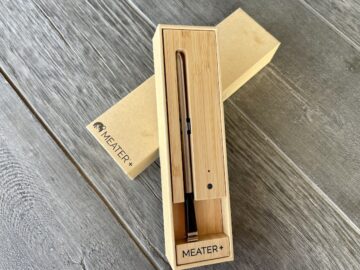 heater plus wireless thermometer in its charging box on a wood grain table