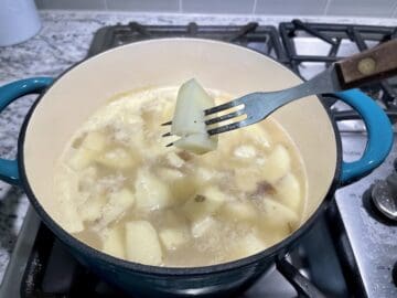 fork tender potatoes in a teal pot