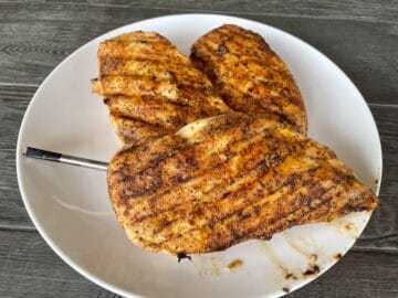 three smoked chicken breasts on a white plate