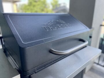Traeger grill outside with blurred trees behind it