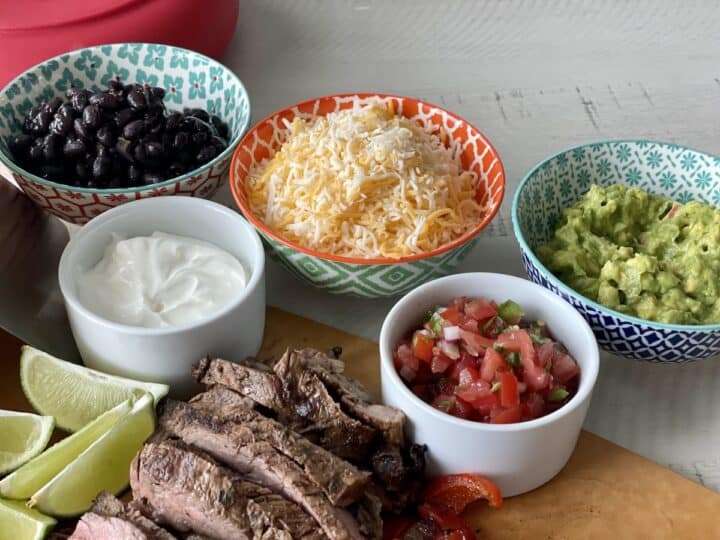 black beans shredded Mexican cheese pico de Gallo and guacamole in small colorful bowls