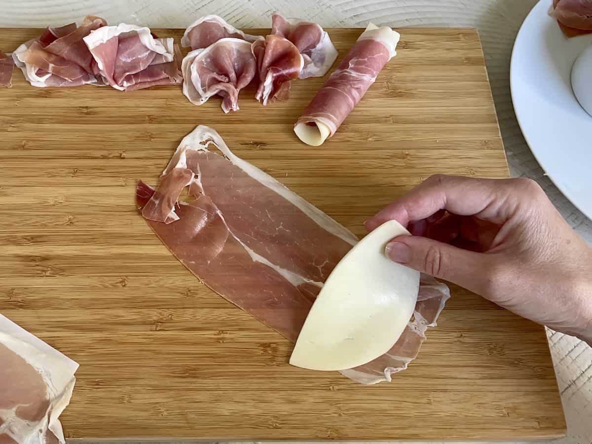 full slice of prosciutto with half of a slice of provolone layered at one end