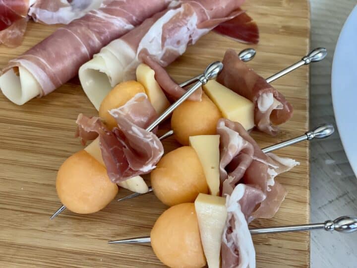 metal skewers with prosciutto cheese wedges and calnteloupe balls