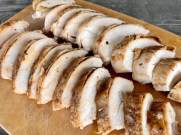 sliced smoked chicken breast on a wood cutting board