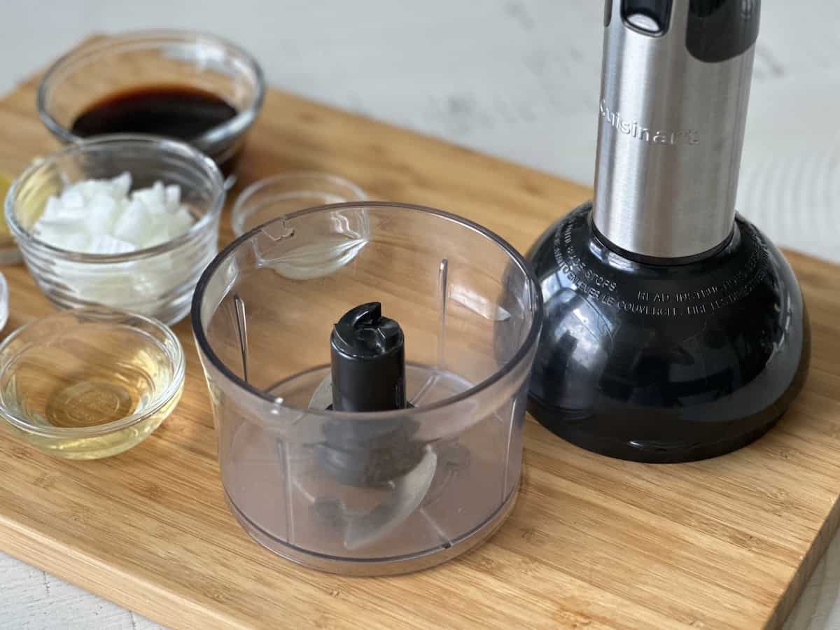 mini food processor and ginger sauce ingredients on a wood cutting board