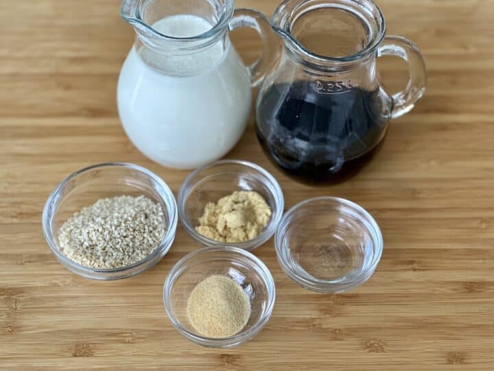 glass bowls and pitchers of mustard sauce ingredients on a wood cutting board