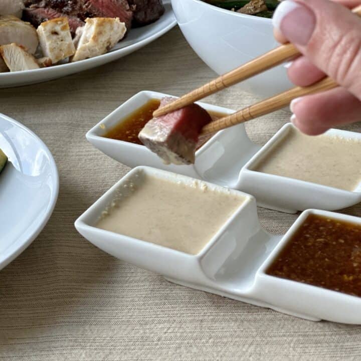 hibachi steak in chopsticks dipping into hibachi mustard sauce