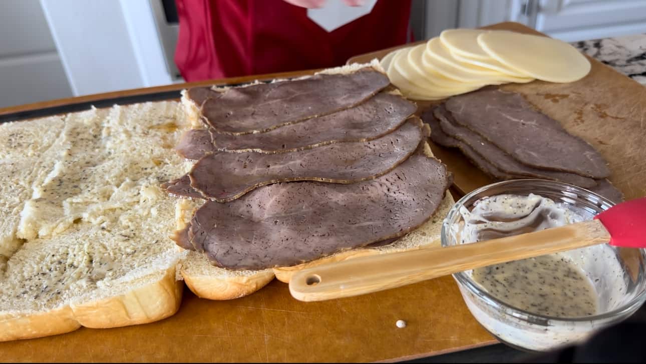 Hawaiian rolls cut in half layers of roast beef on top