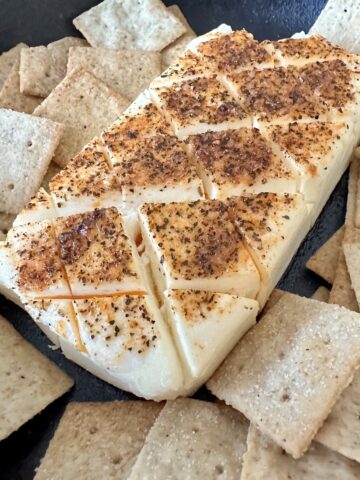 smoked cream cheese in cast iron skillet with square crackers around it