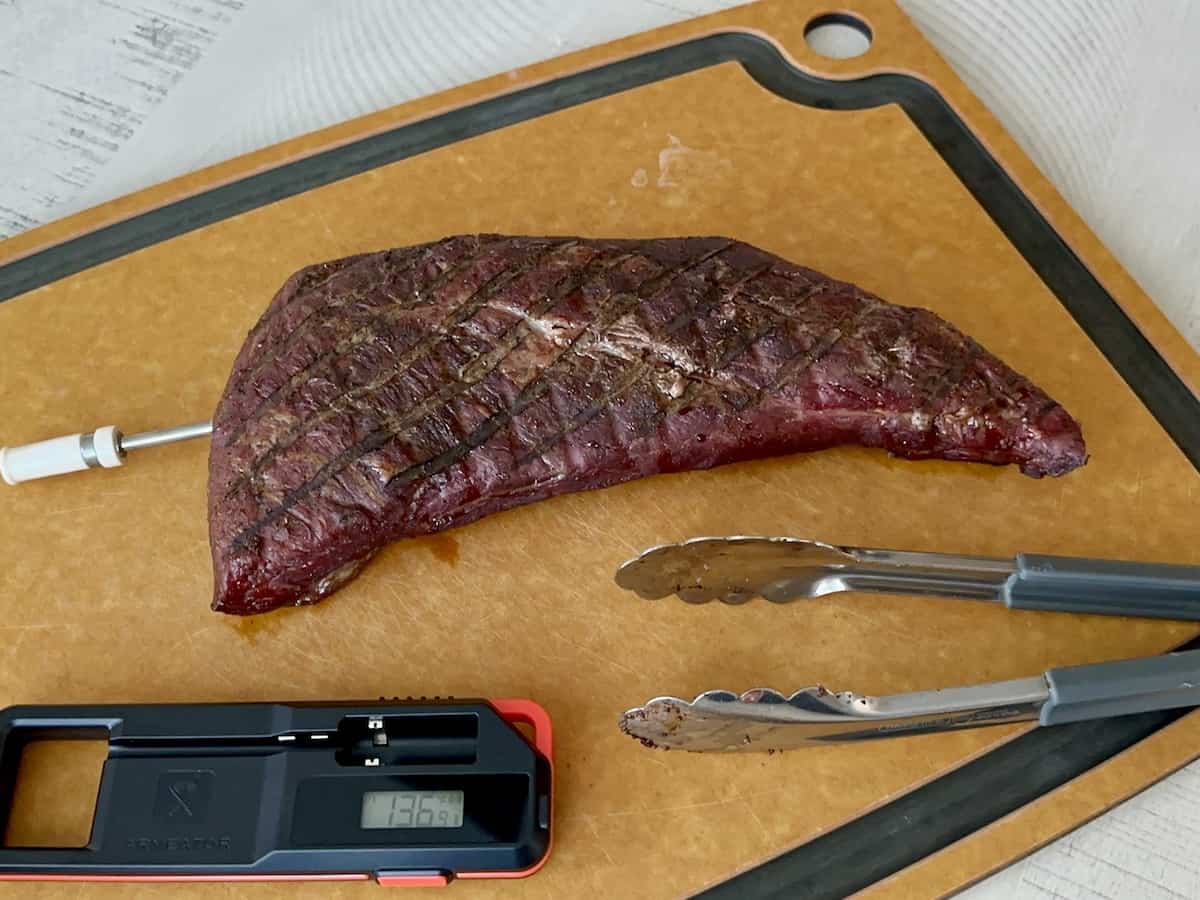 smok tri tip on cutting board with armeator thermometer base and tongs