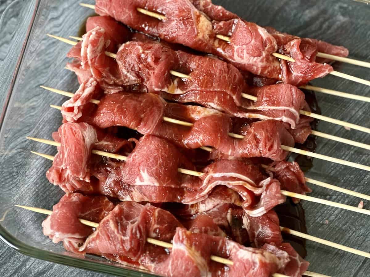 uncooked beef skewers in marinade