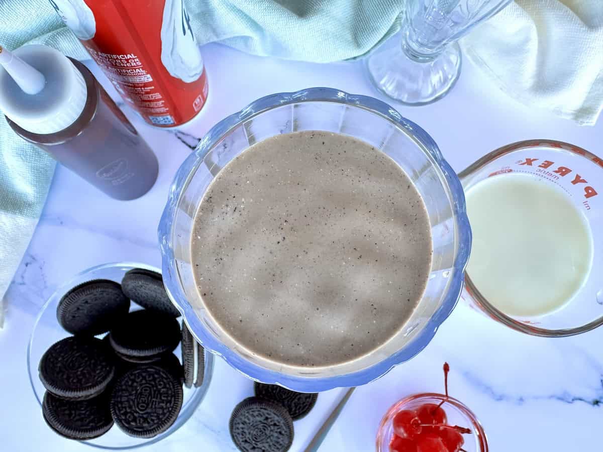 chocolate shake in glass milkshake toppings around the glass