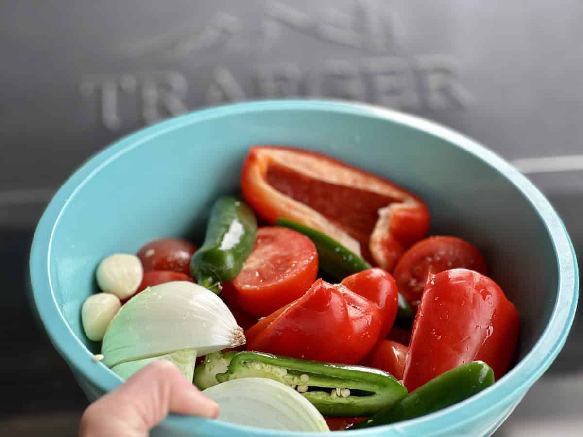 cut salsa vegetables in big blue bowl Traeger in the background