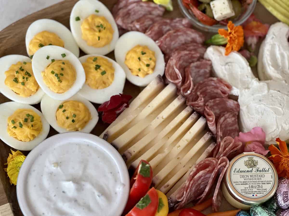 deviled eggs ranch dip sliced cheese folded salmi on wood charcuterie board