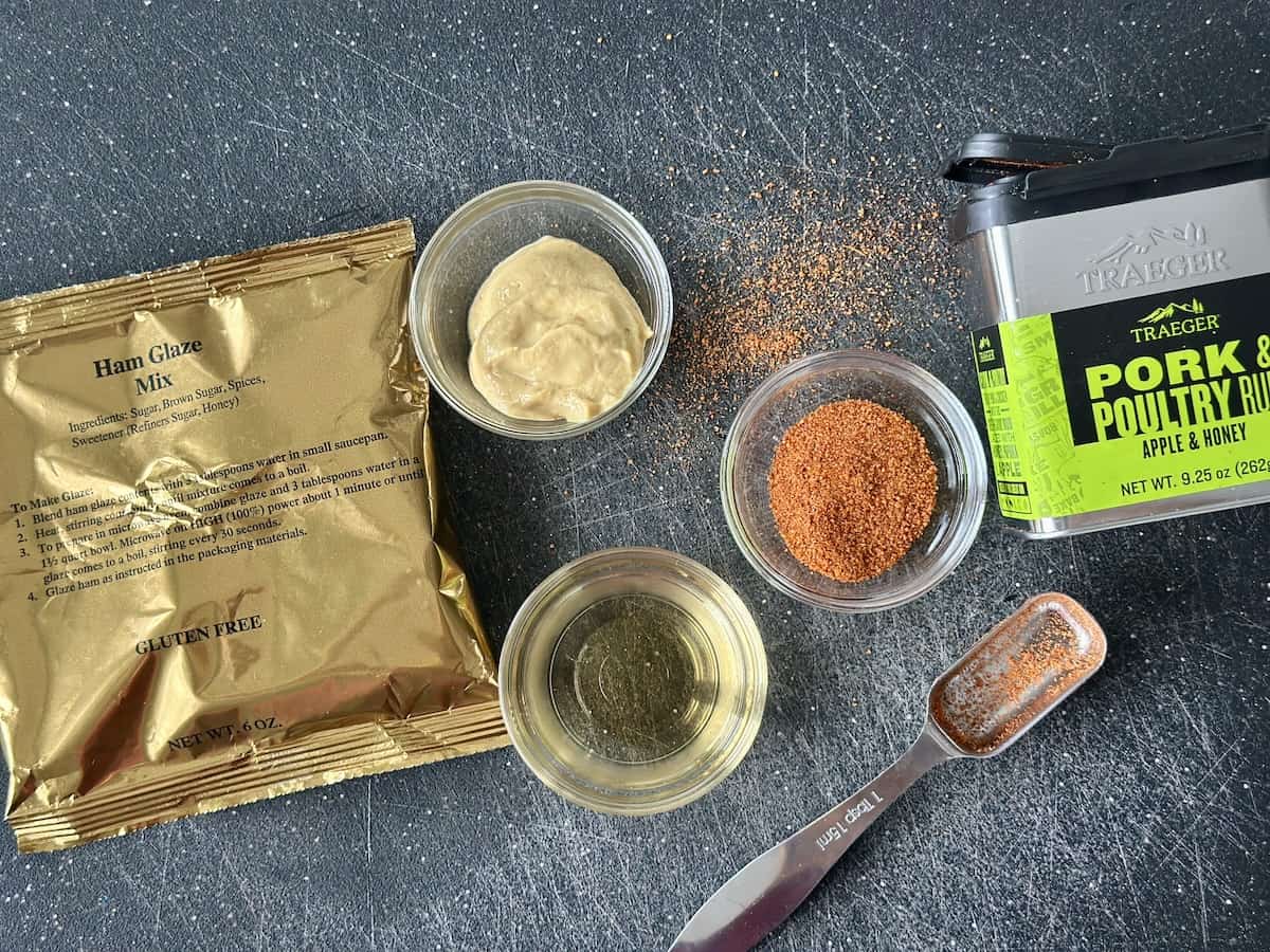 gold glaze packet small glass bowls on dijon mustard apple juice and traeger pork and poultry with tablespoon on black cutting board