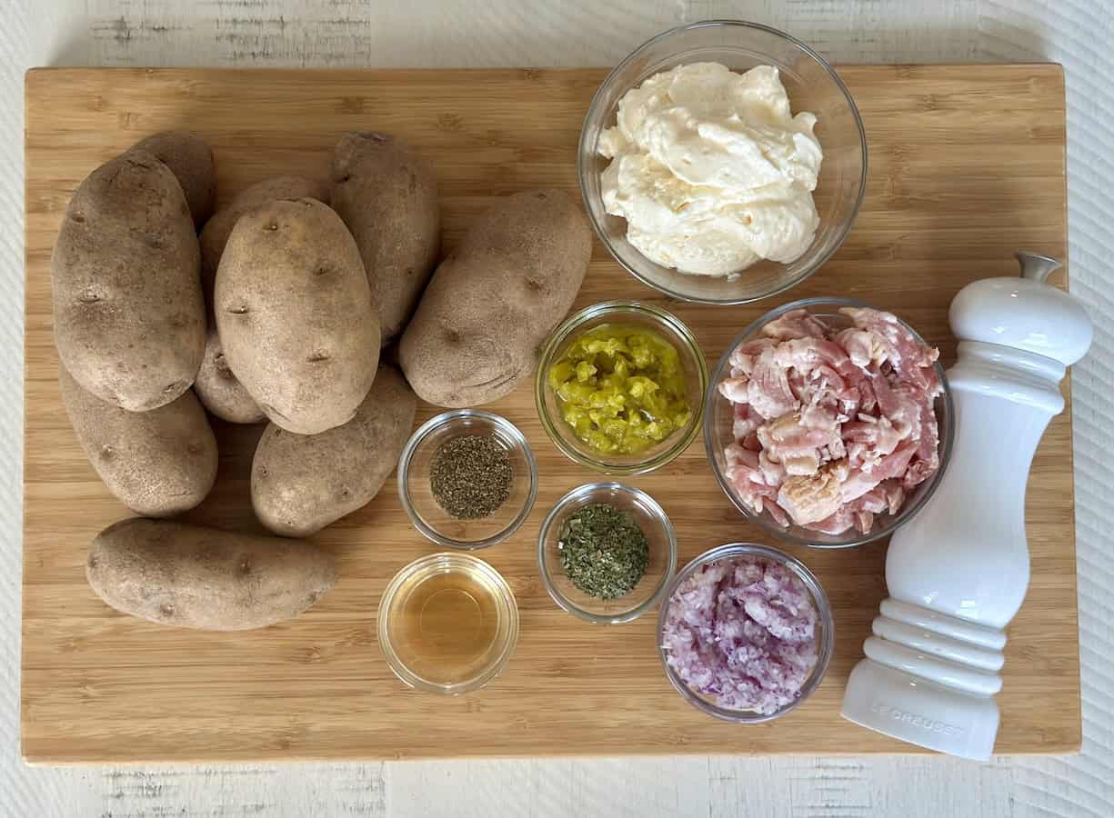 Potatoes, bacon, and other ingredients on a cutting board
