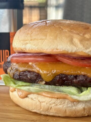 smoked cheeseburger on wood cutting board traeger rub