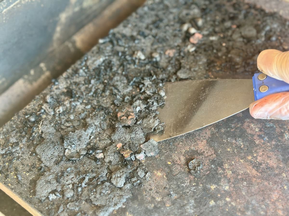 scraping drip pan with putty knife