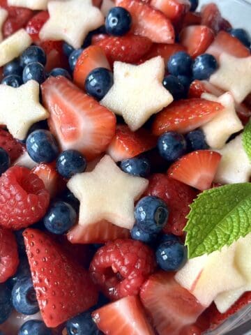 apple stars raspberries strawberries and blueberries in bowl