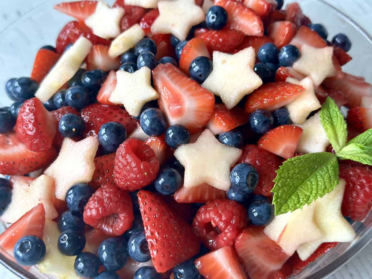 apple stars raspberries strawberries and blueberries in bowl