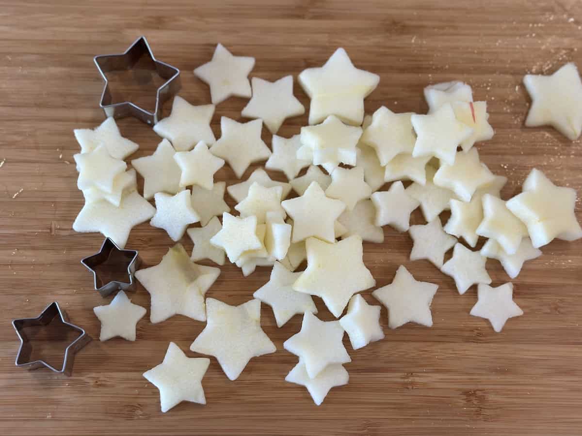 apple stars and star cookie cutters on wood cutting board
