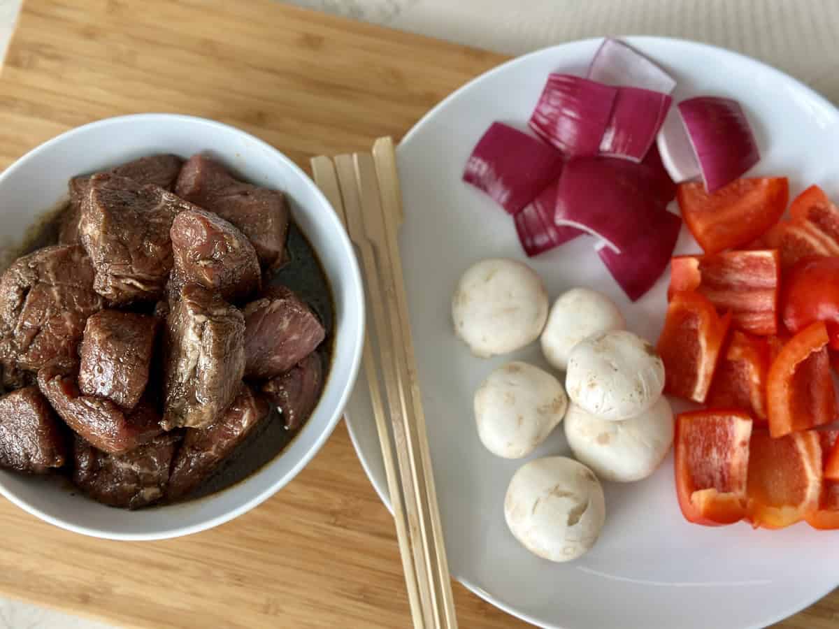 marinated steak and cut bell pepper red onion and white mushrooms