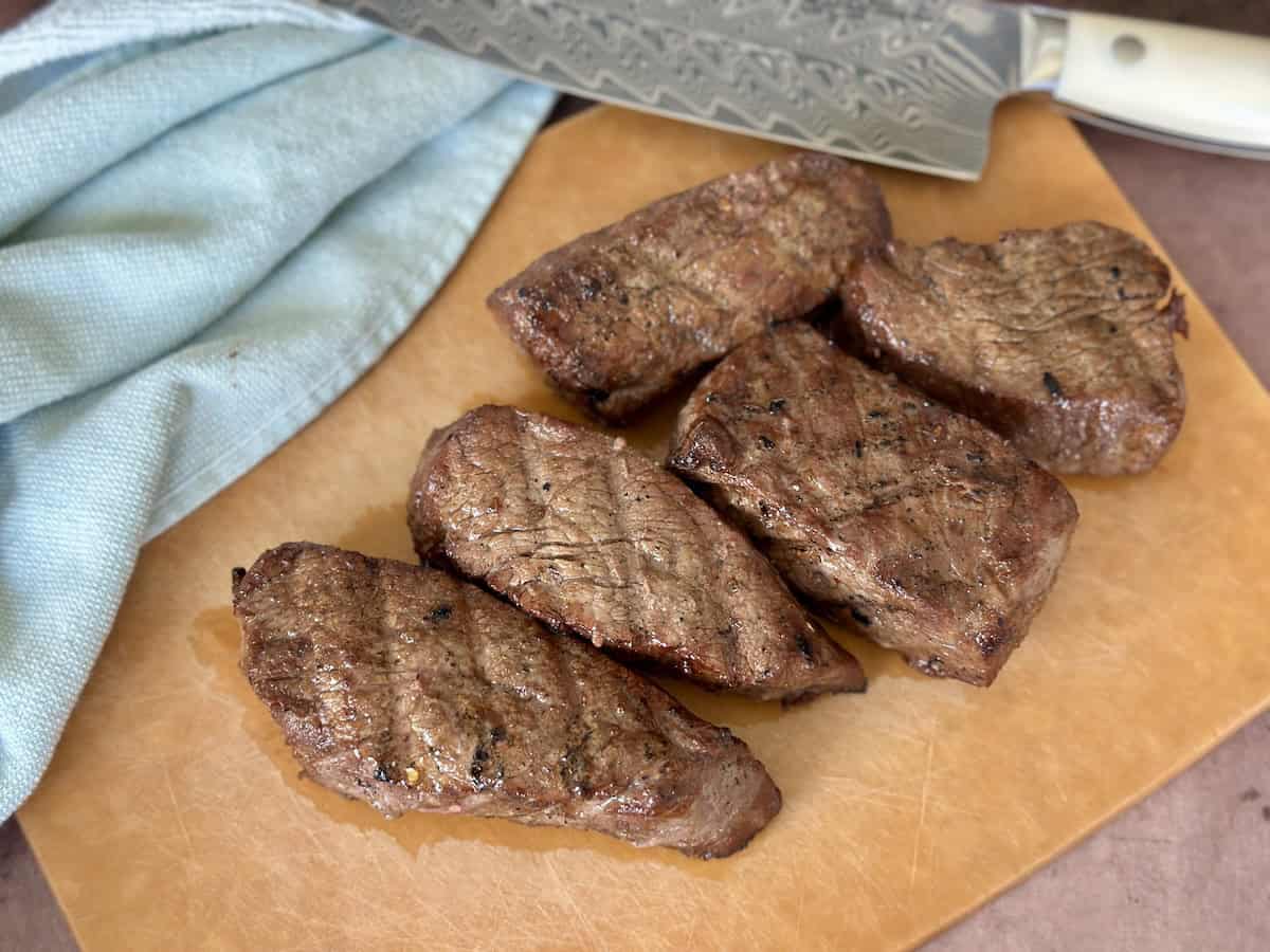 tri tip steaks on wood cutting board