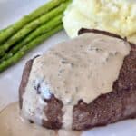 Juicy beef steak topped with peppercorn cream sauce, served with fresh asparagus and mashed potatoes