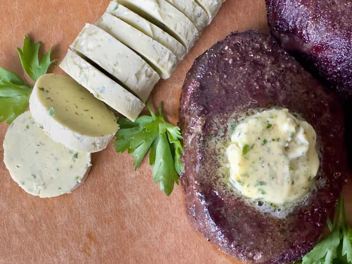 sliced garlic butter rounds cooked steak with butter on wood cutting board
