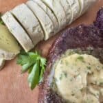sliced garlic butter rounds cooked steak with butter on wood cutting board