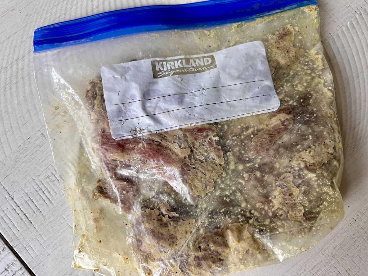 flap steak and marinade in zip top bag on kitchen table
