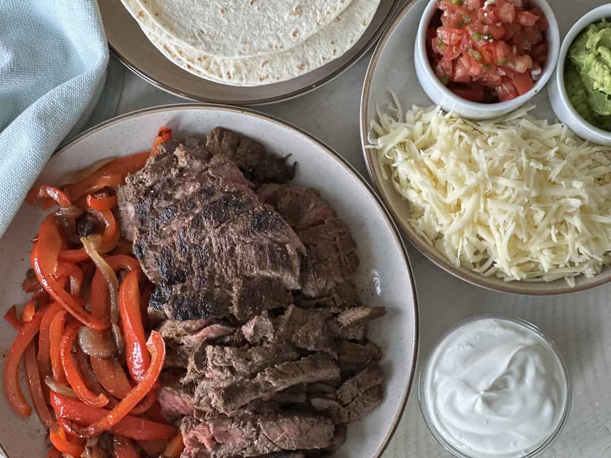 sliced fajita steak and toppings 