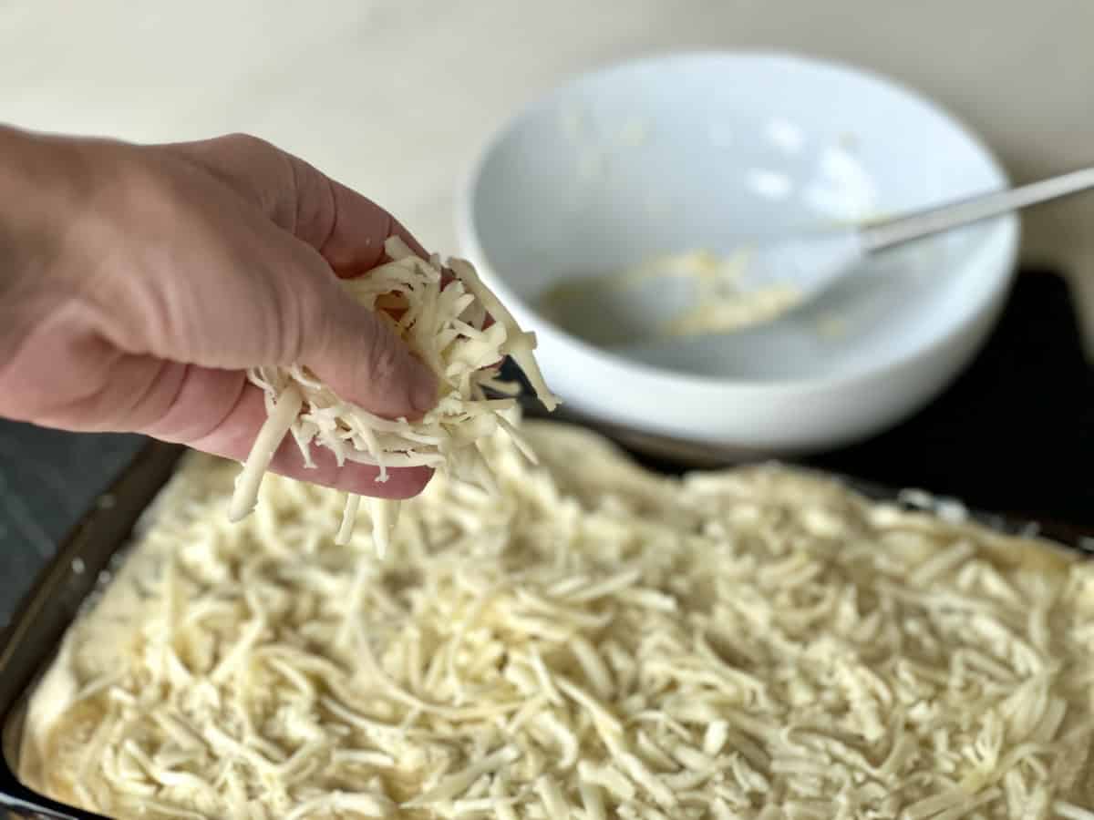 shredded cheese being sprinkled on casserole