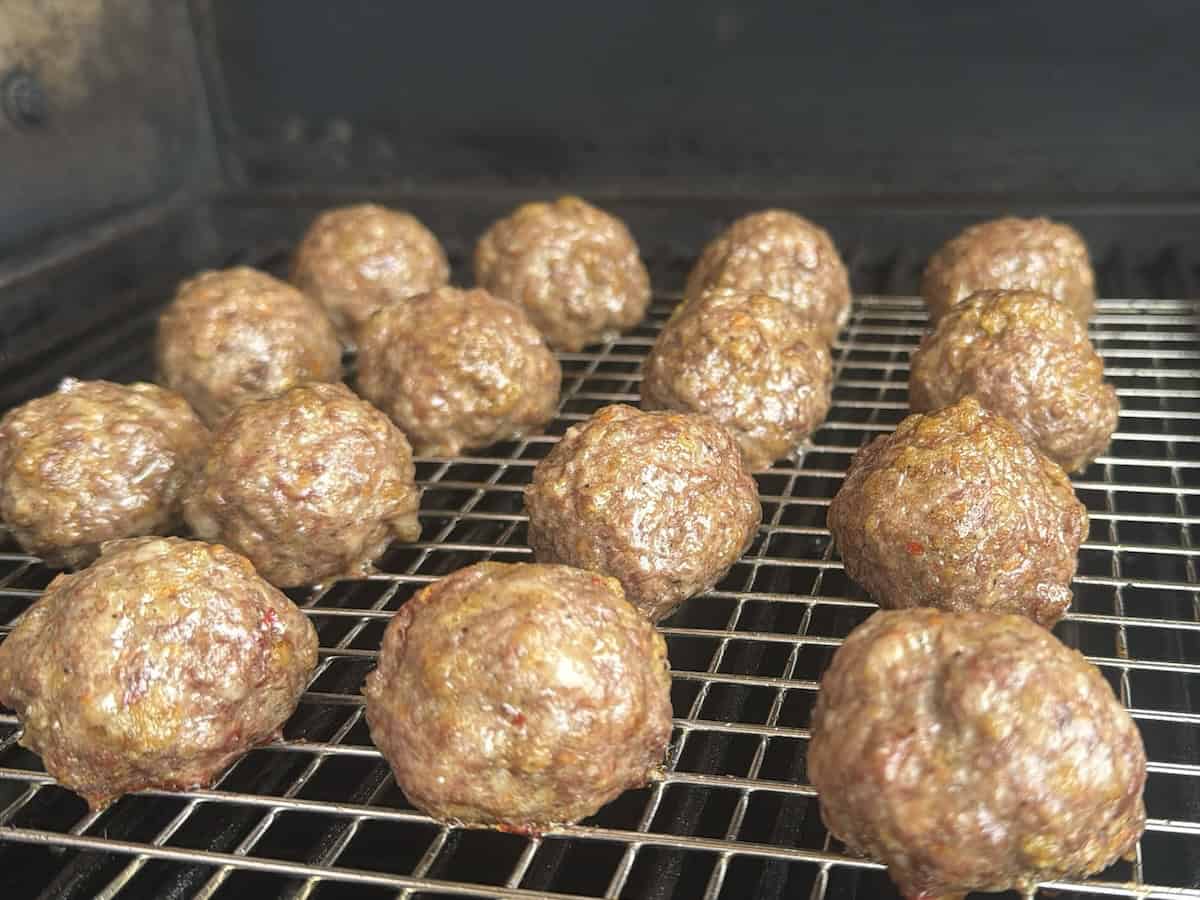 meatballs smoking on wire rack in pellet smoker
