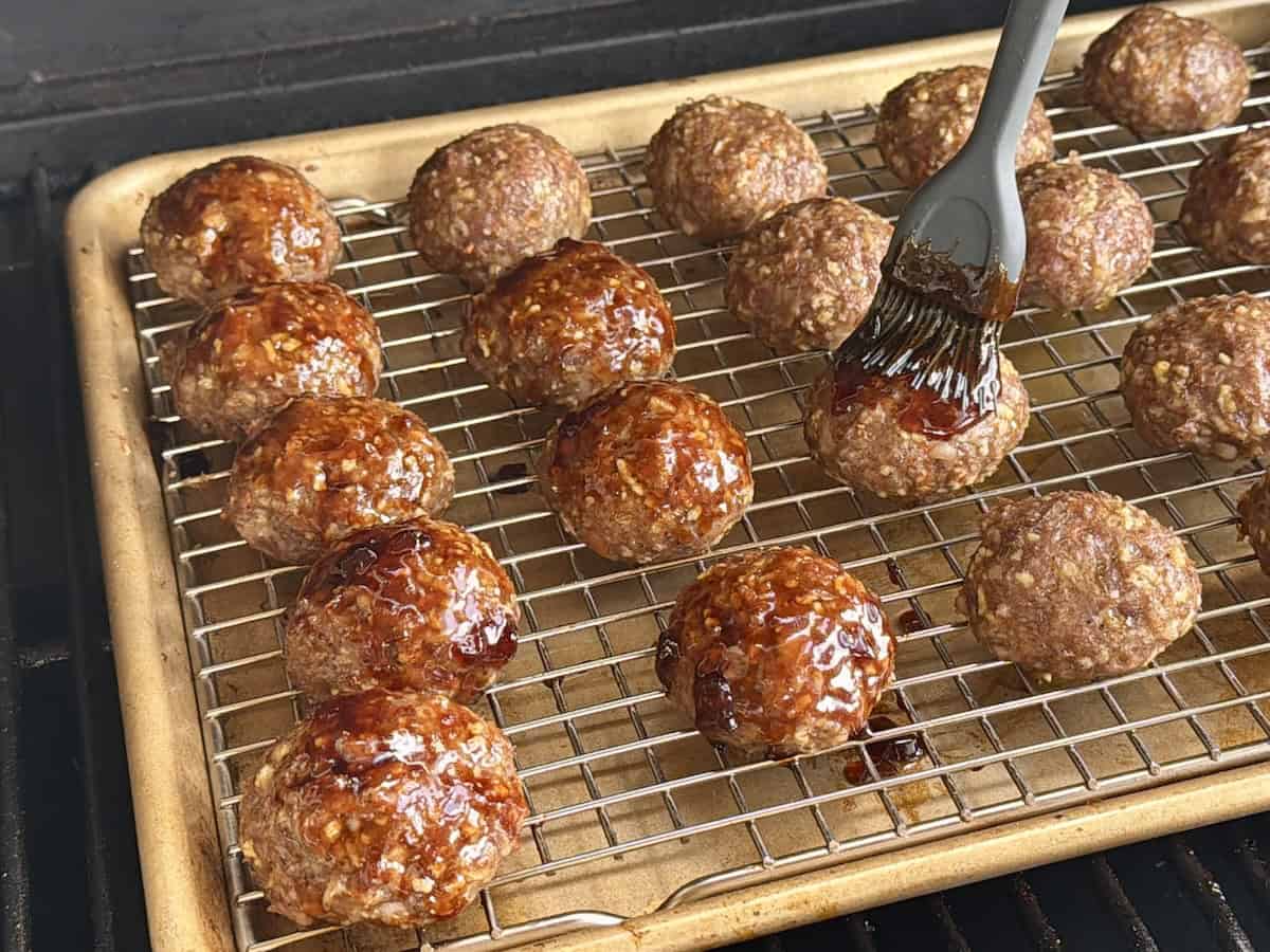 smoked meatballs on grill brushed with sauce